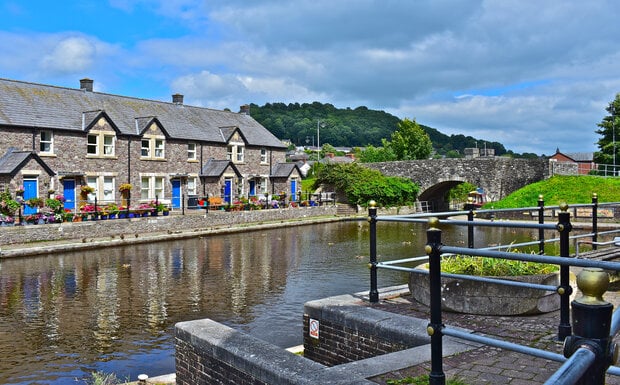 A terraced row of pretty cottages alongside the canal basin of the Monmouthshire and Brecon Canal in Powys, Wales.