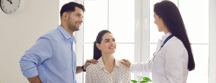 A male and female couple are pictured consulting with a female doctor about starting a family.