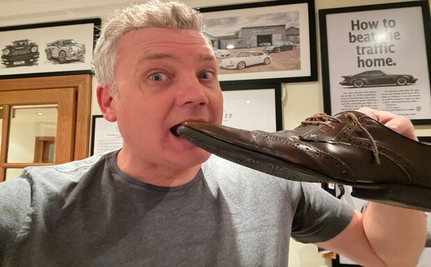 TV pundit and property expert Russell Quirk is pictured at home in his study pretending to eat one of his shoes.
