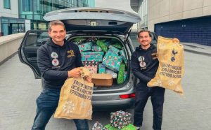 Location Location’s Basil Fansa and Jason Heightman are stood behind the open boot of a car packed with presents ready to be delivered while they are holding sacks of presents.