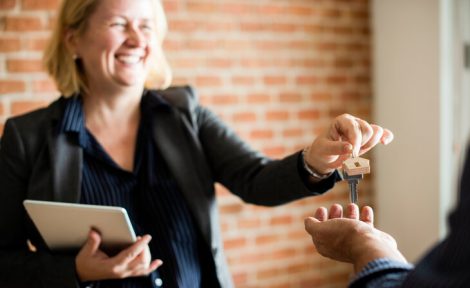 A female estate agent is pictured handing over keys to a new homeowner.