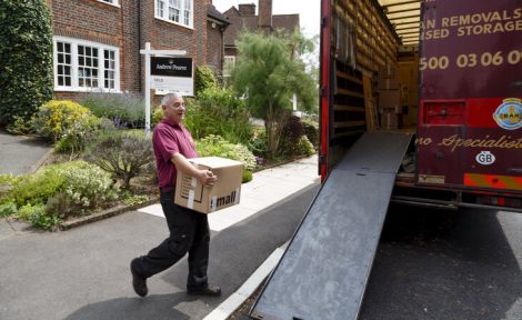 A moving van is pictured in a treelined road and a removal man is loading it up after tenants have been forced to move due to the property being sold.