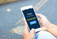 Person holding phone with google reviews screen