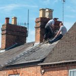 Two men fixing a roof